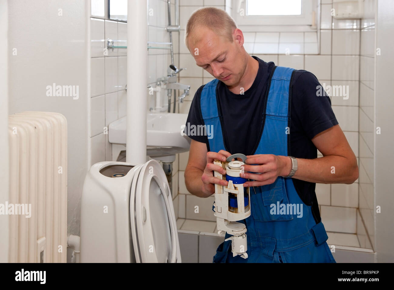 Heating and sanitary technician repairing the toilet cistern Stock Photo Alamy