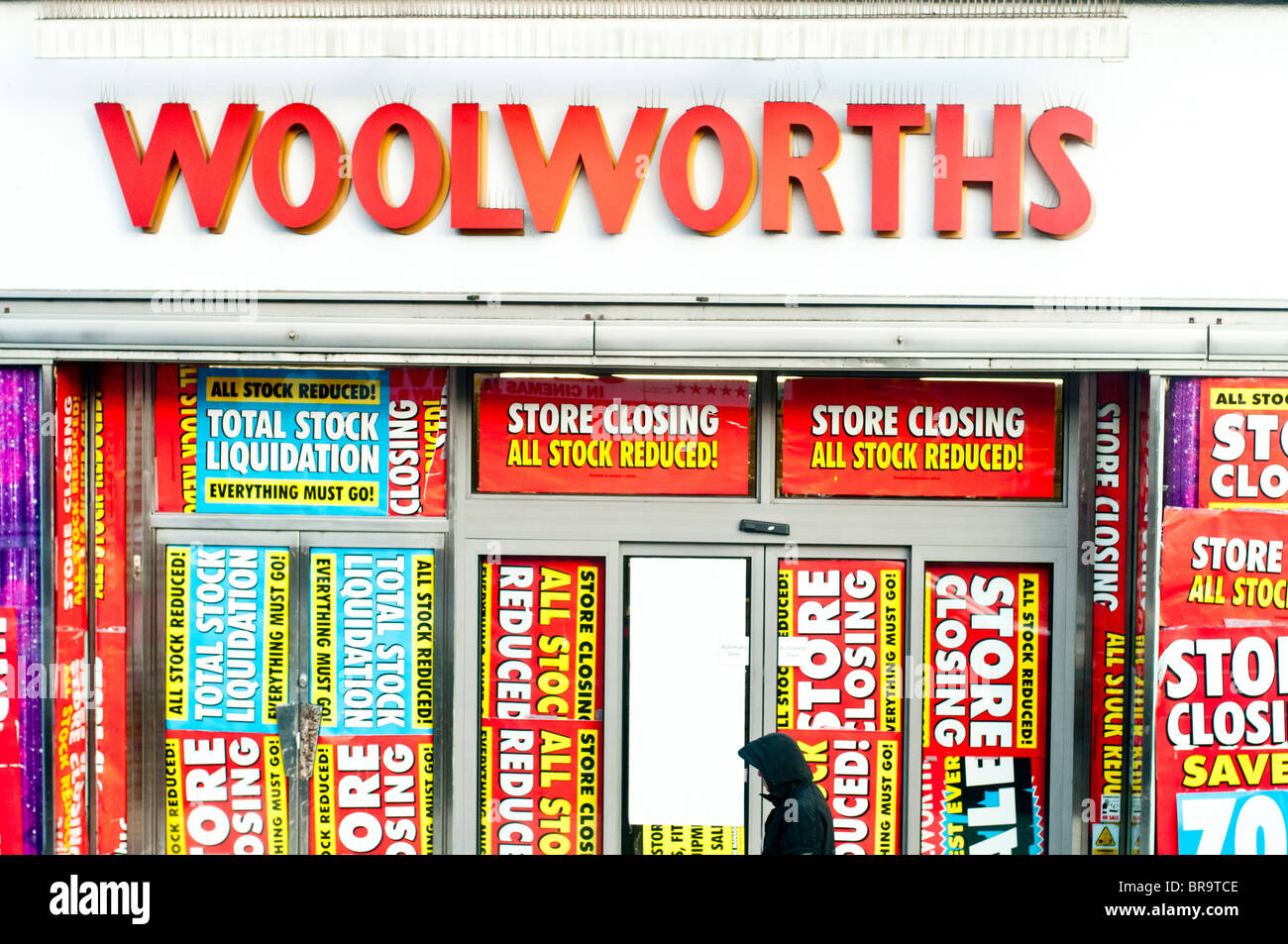 Retail shop WOOLWORTHS going out of business  closing down. Heavy discount signs on window display Last days 80% off Stock Photo