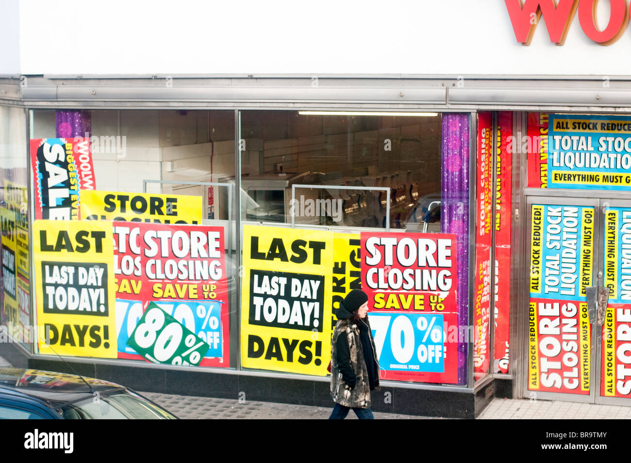 Retail shop WOOLWORTHS going out of business closing down. Heavy discount signs on window display Last days 80% off Stock Photo