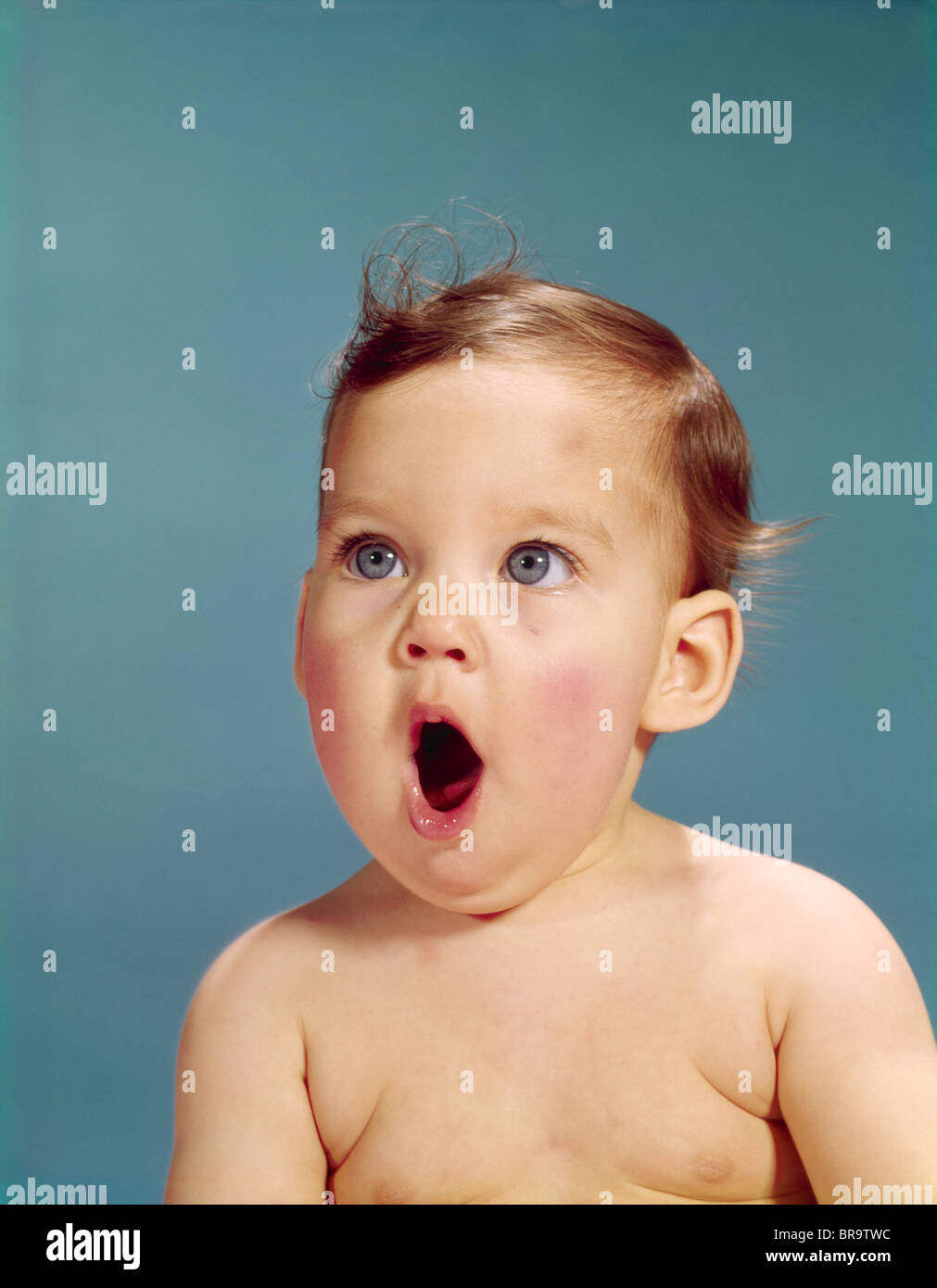 1960s BABY PORTRAIT MOUTH WIDE OPEN SHOCKED FACIAL EXPRESSION Stock Photo