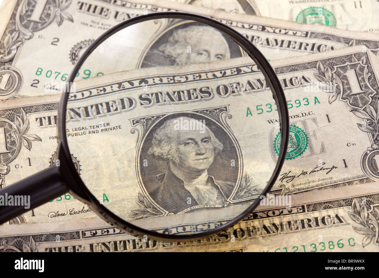 magnifying glass examining dollar banknotes Stock Photo Alamy