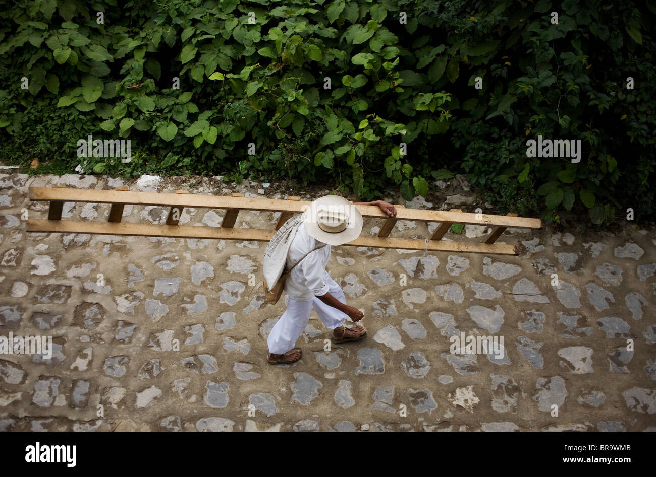 A Nahuatl indigenous man carries a ladder in Cuetzalan del Progreso Mexico Stock Photo
