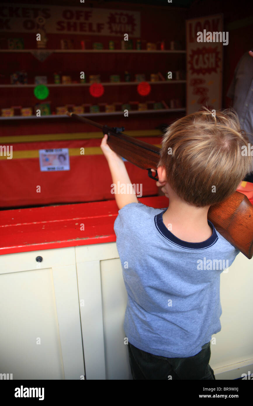 Boy shooting with an air rifle in an arcade game at Challock Goose Fair