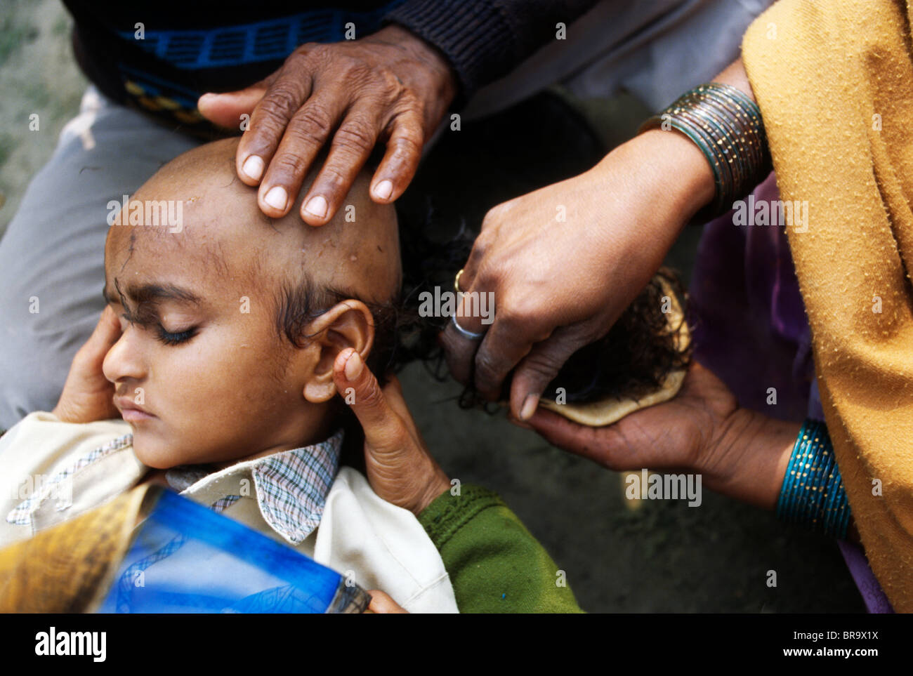 Parents shaving head of their child during Chudakarana Samskara in