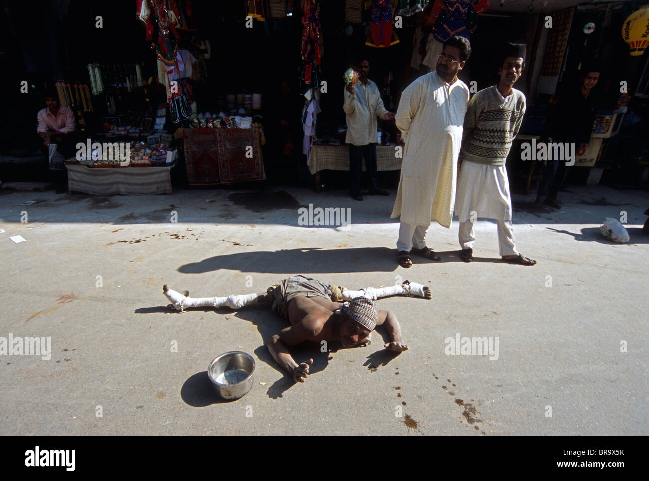 Disabled beggar lying on a street India. Stock Photo