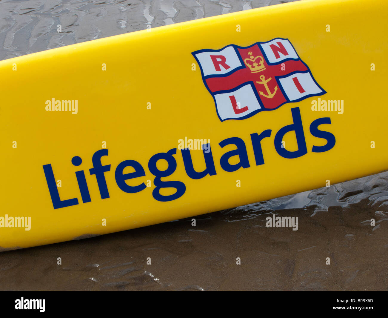 Lifeguards' surfboard on sand Stock Photo