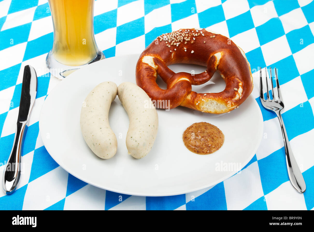 Bavarian veal sausage setup with beer and blue white background Stock Photo