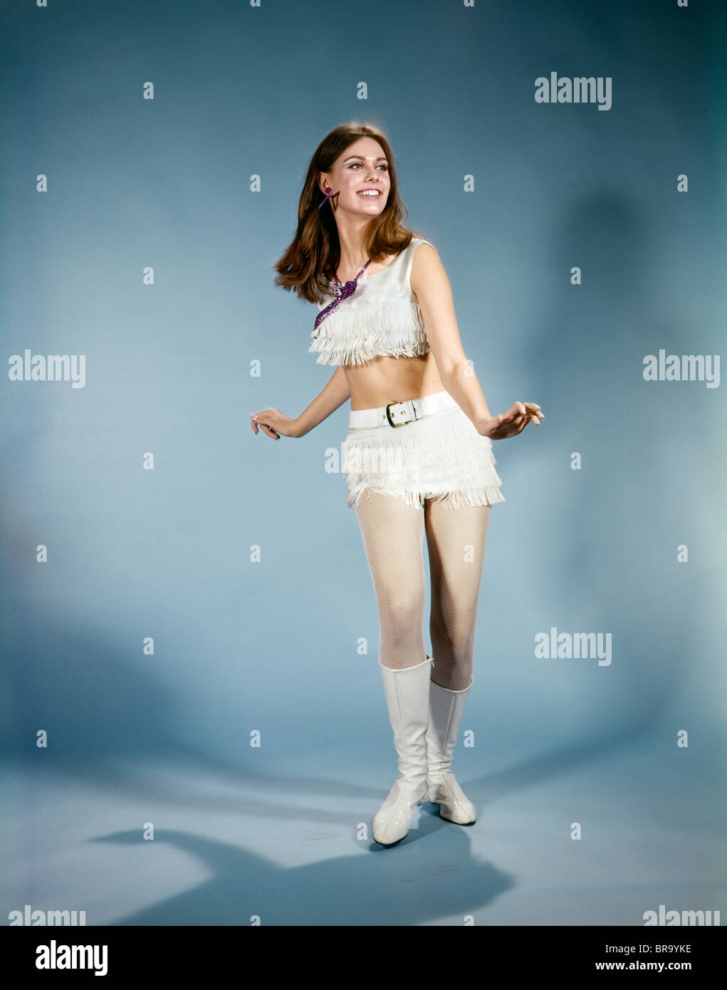1970s YOUNG WOMAN DANCING WHITE FRINGED HOT PANTS GOGO BOOTS Stock Photo