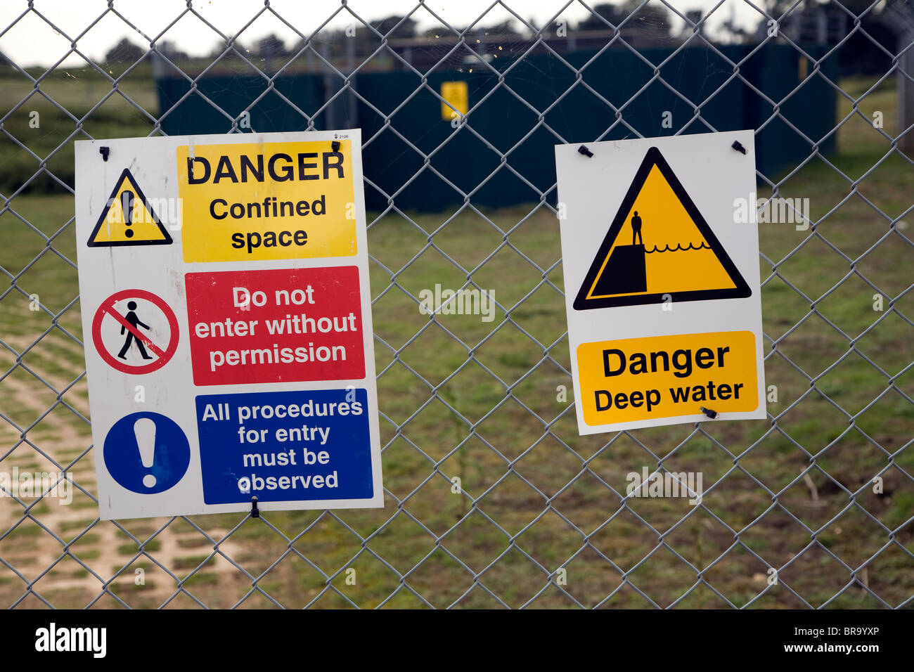 Danger signs on fence of sewage works Sutton Heath, Suffolk, England Stock Photo