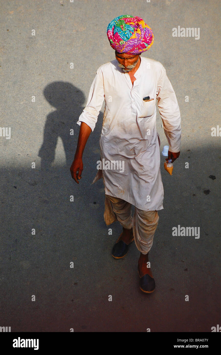 An Indian man walking through the City of Lakes Udaipur wearing a traditional Indian turban Stock Photo