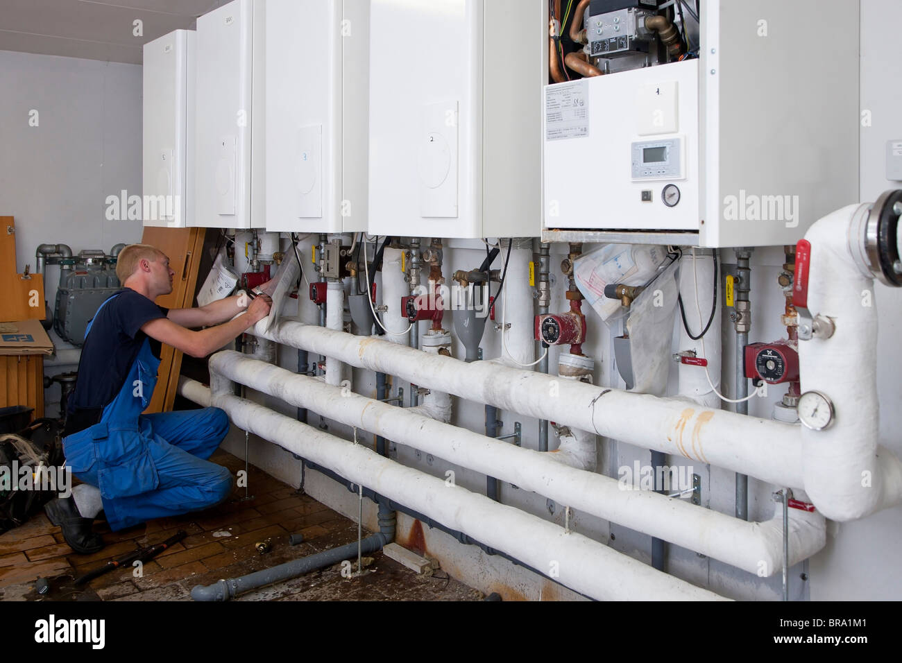 Heating and sanitary technician testing and adjusting a gas heater