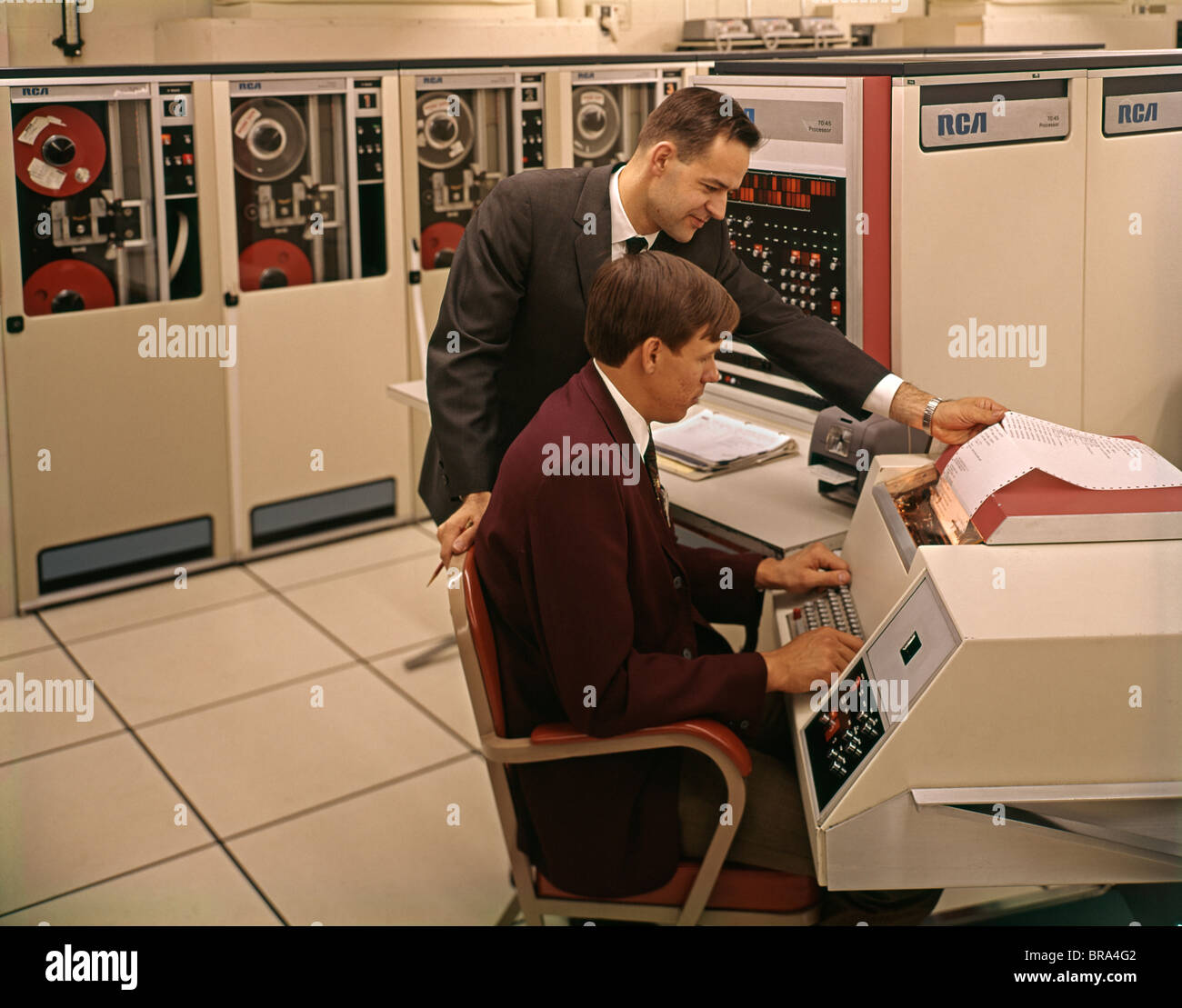 1960s 1970s TWO MEN TECHNICIANS WORKING ON MAINFRAME COMPUTER Stock Photo