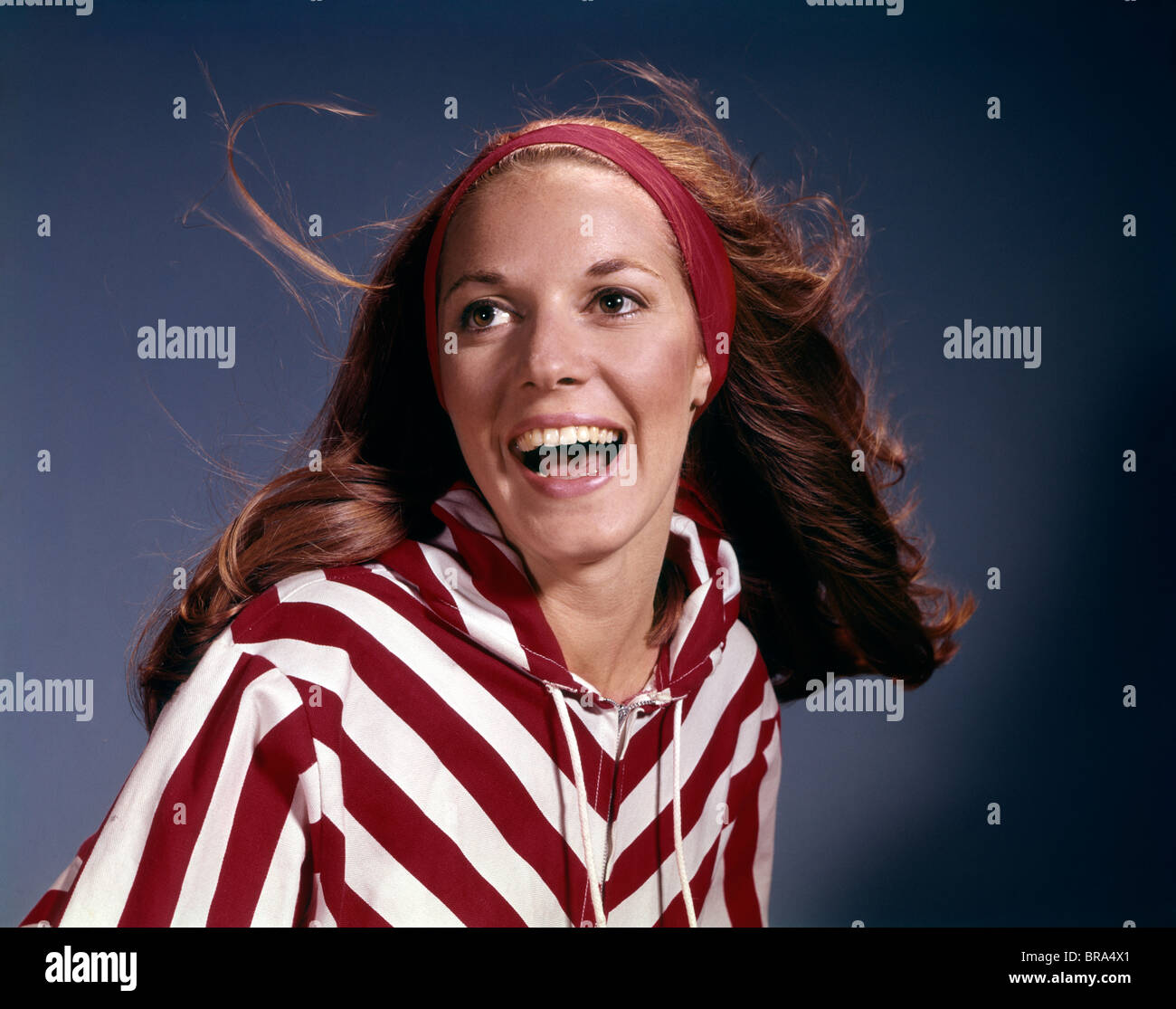 1960s PORTRAIT SMILING LAUGHING WOMAN RED HEADBAND STRIPED JACKET FASHION RETRO Stock Photo