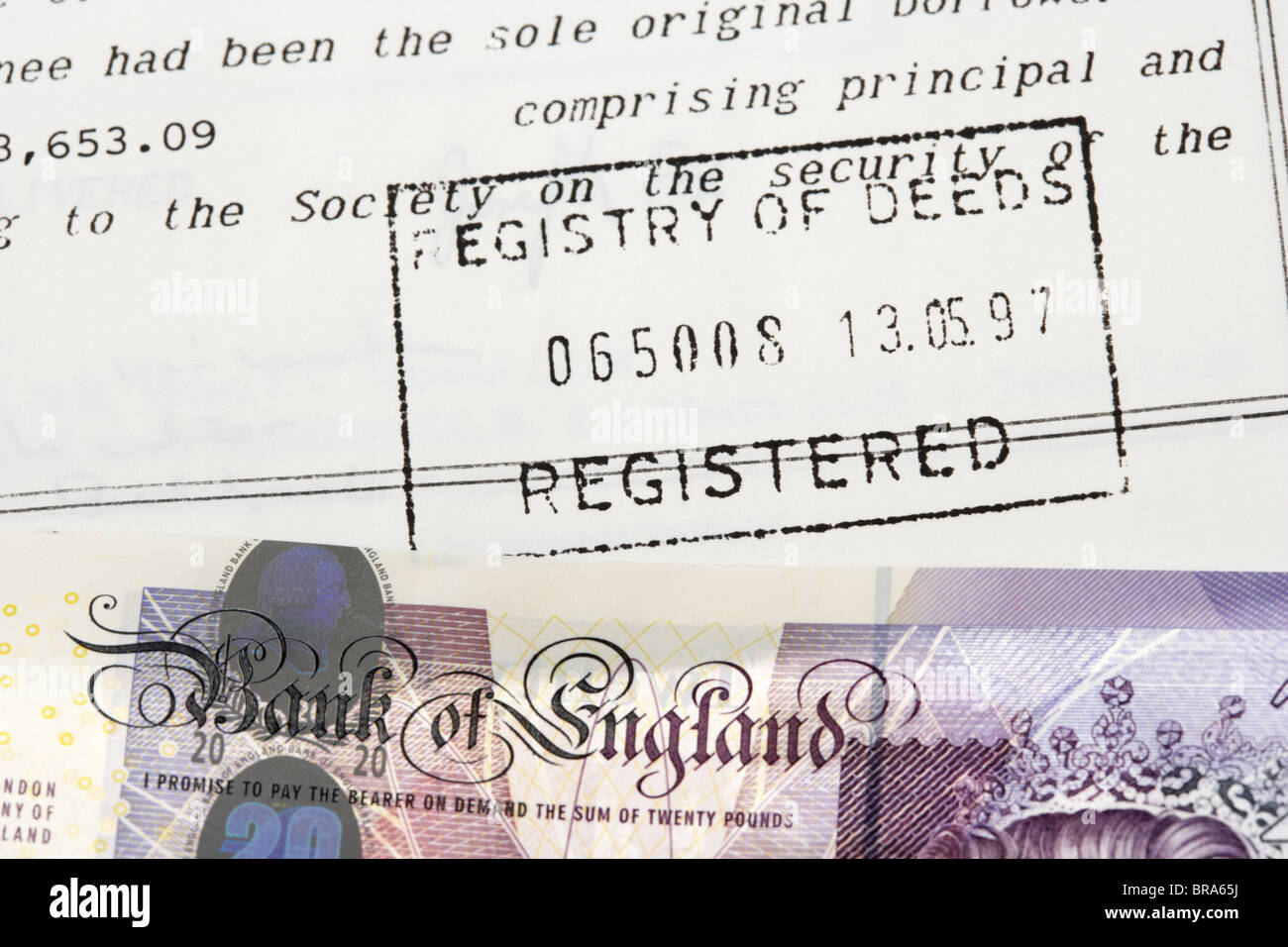 house contract deeds stamped by the registry of deeds with a twenty pounds sterling banknote Stock Photo