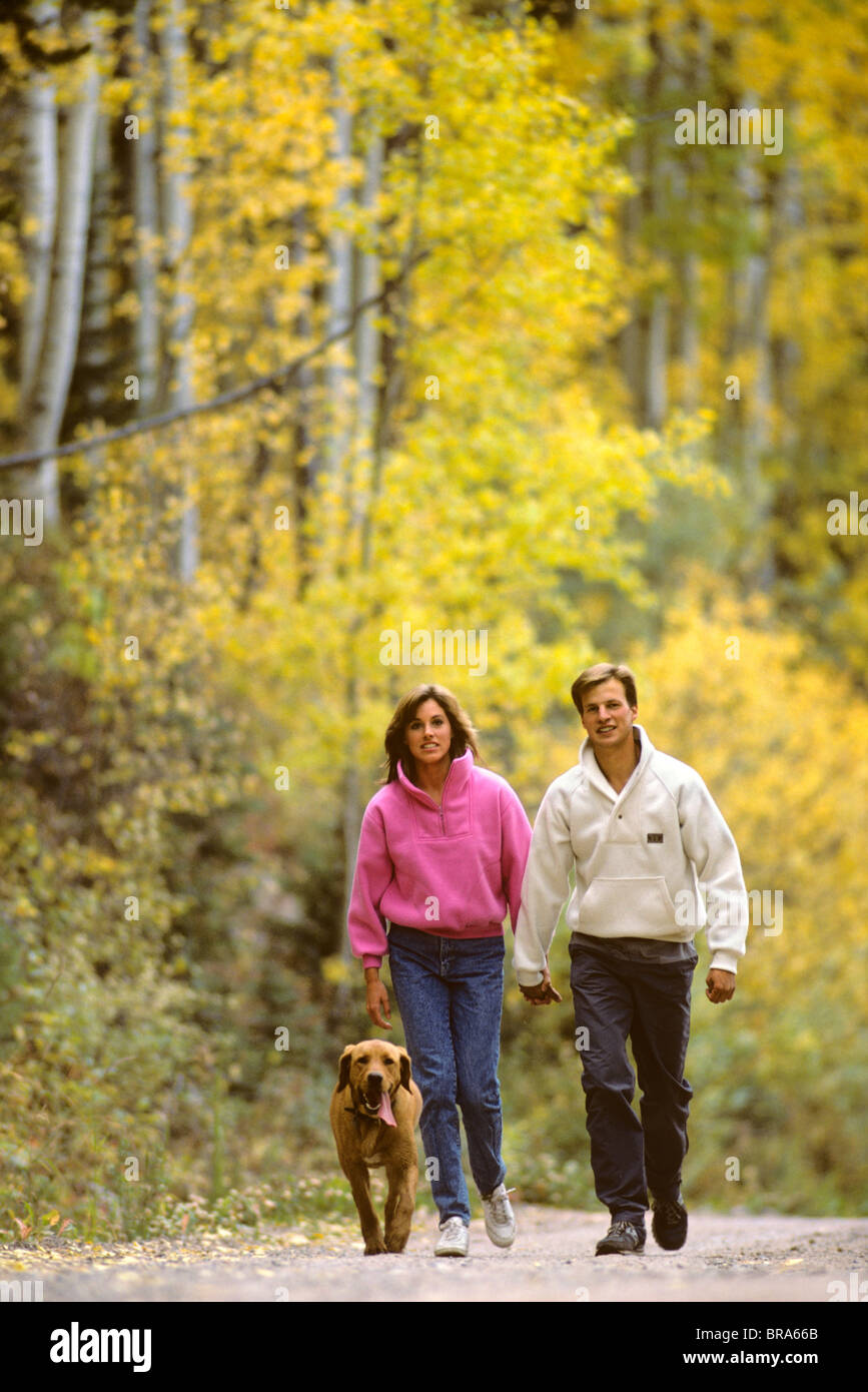 COUPLE WALKING WITH DOG Stock Photo - Alamy