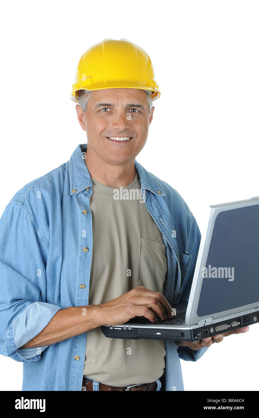 Construction Worker Holding Laptop and smiling at the camera. Vertical Format isolated over white. Stock Photo