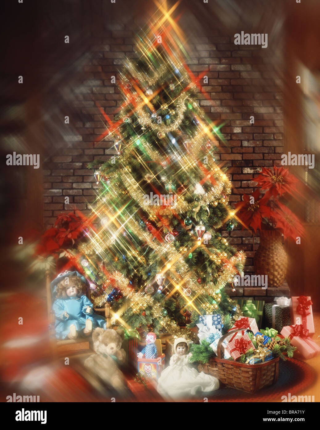 CHRISTMAS TREE WITH DEOCRATONS GARLAND LIGHTS TOYS AND PRESENTS UNDER TREE BLURRED EFFECT Stock Photo