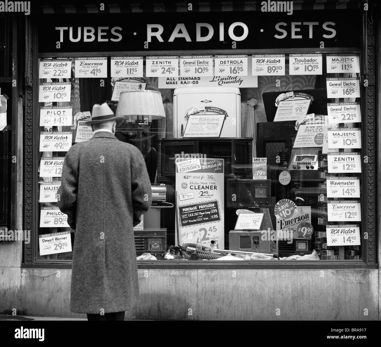 1940s MAN LOOKING AT WINDOW DISPLAY OF RADIOS ON SALE IN NEW YORK CITY Stock Photo