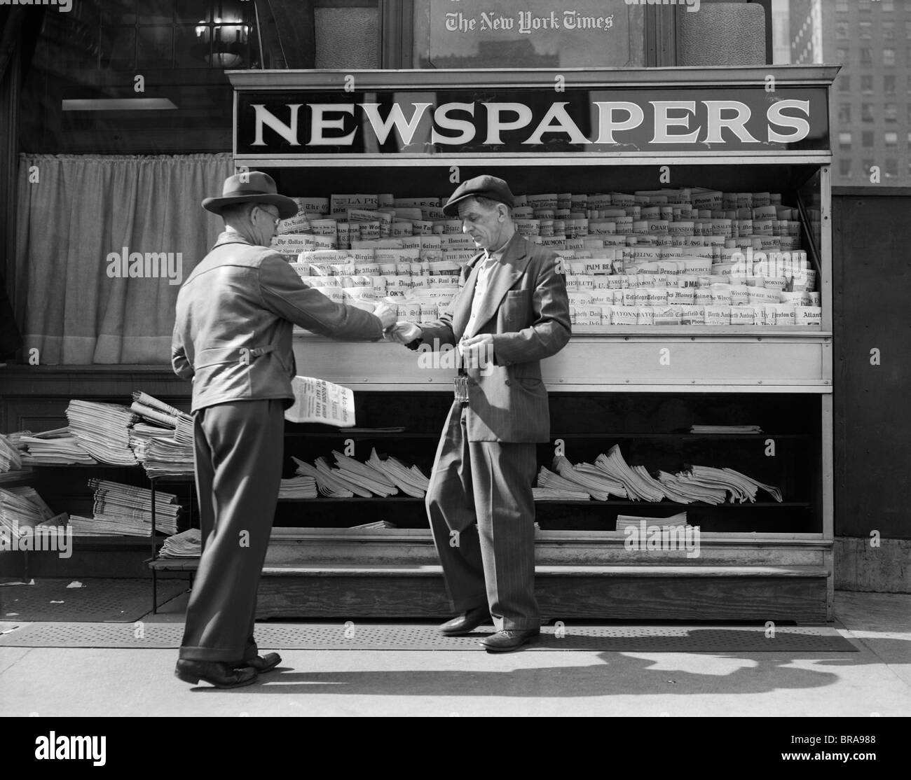 1940s MAN BUYING NEWSPAPER FROM VENDOR ON SIDEWALK NEW YORK CITY Stock Photo