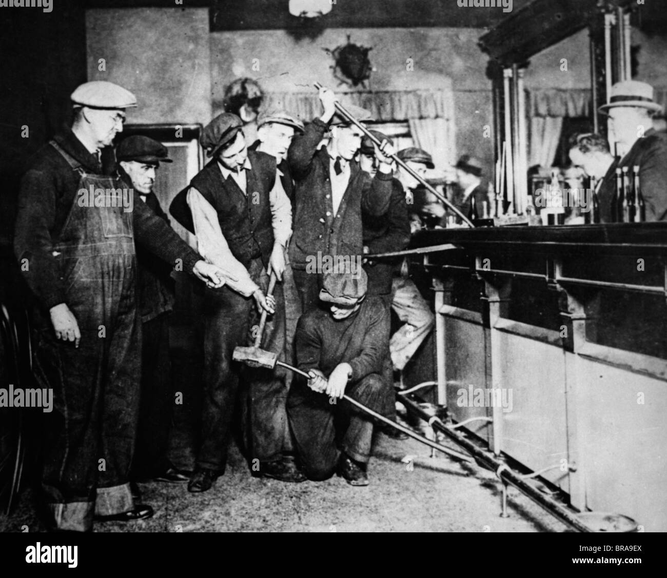 1920s 1930s PROHIBITION RAID FEDERAL AGENTS RIPPING UP DESTROYING BAR TO SEE IF LIQUOR IS HIDDEN Stock Photo