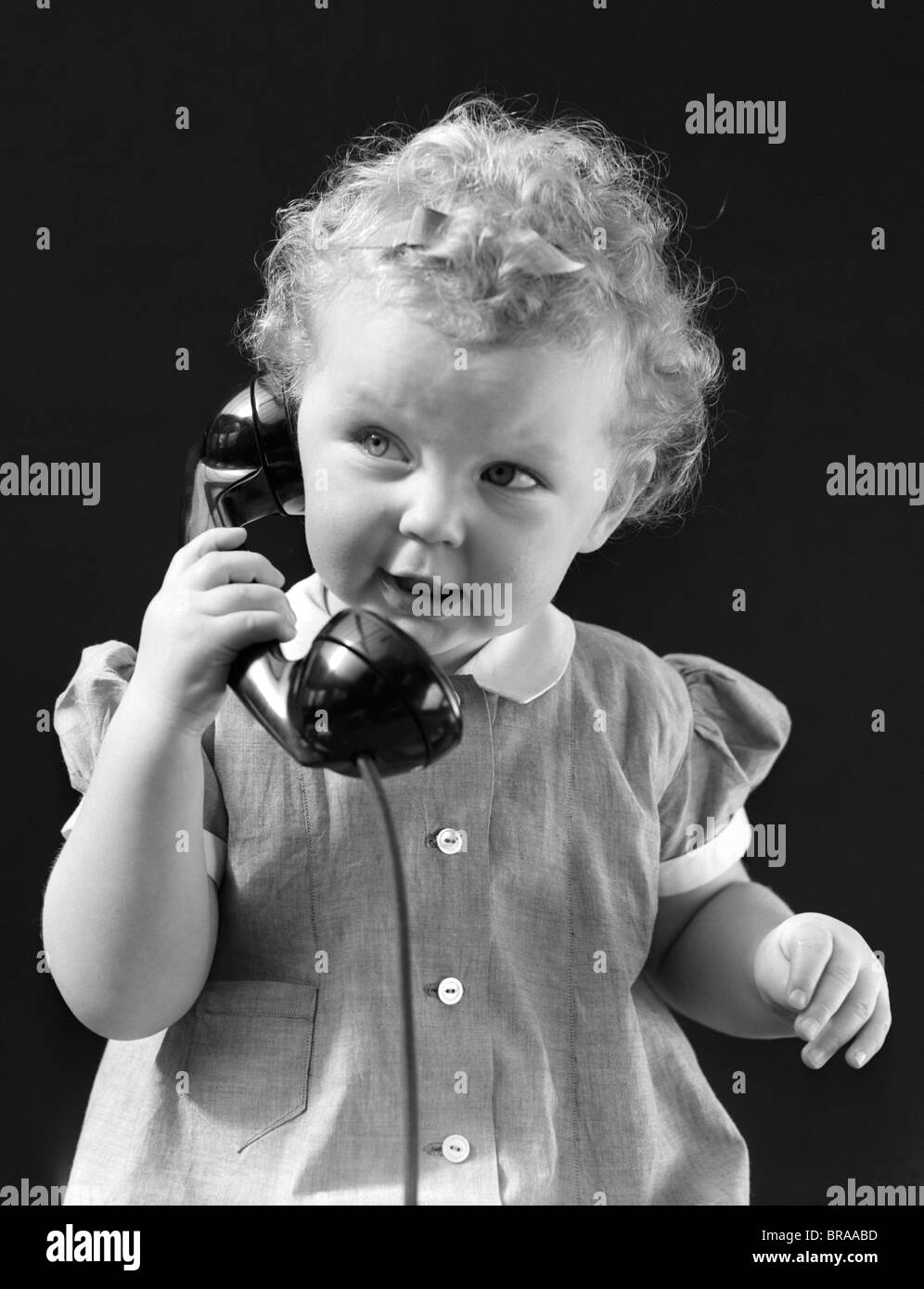 1930s 1940s Curly Haired Girl Toddler Talking On Telephone Stock