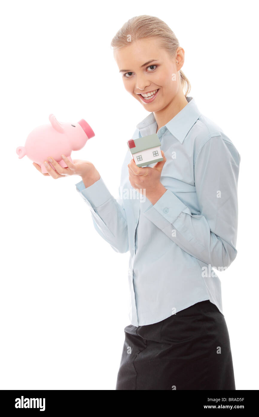 Young beautiful business woman with house model and piggy bank in hands ...