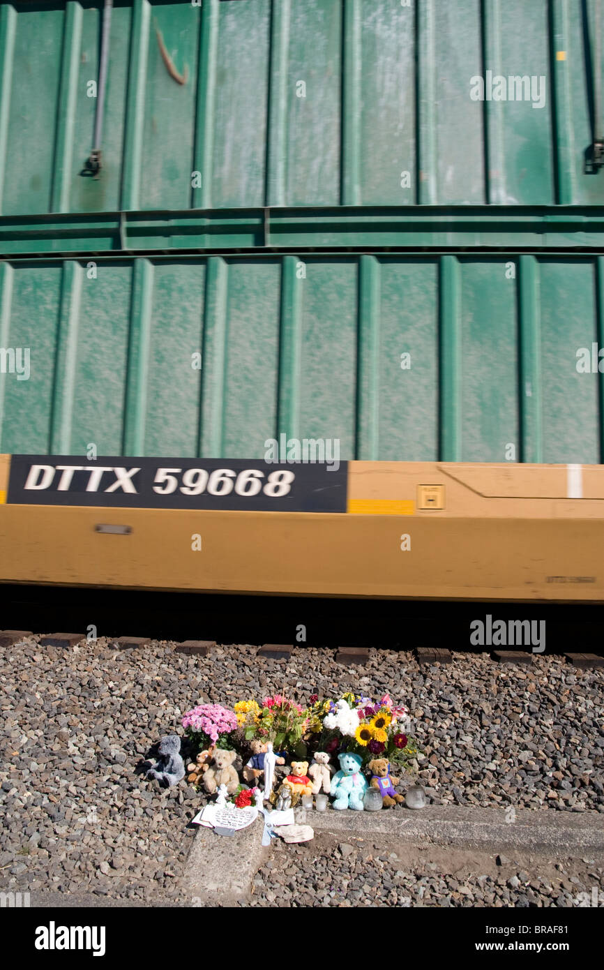 Freight Train passes memorial flowers by BNSF railroad tracks at Tacoma WA USA United States of America Stock Photo