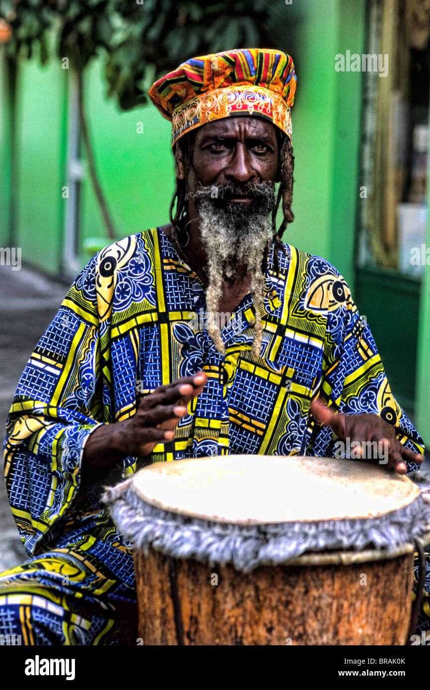 Colorful Rasta Jamaican Reggae performer on drum in costume at Harbour in  St John Antigua Stock Photo - Alamy