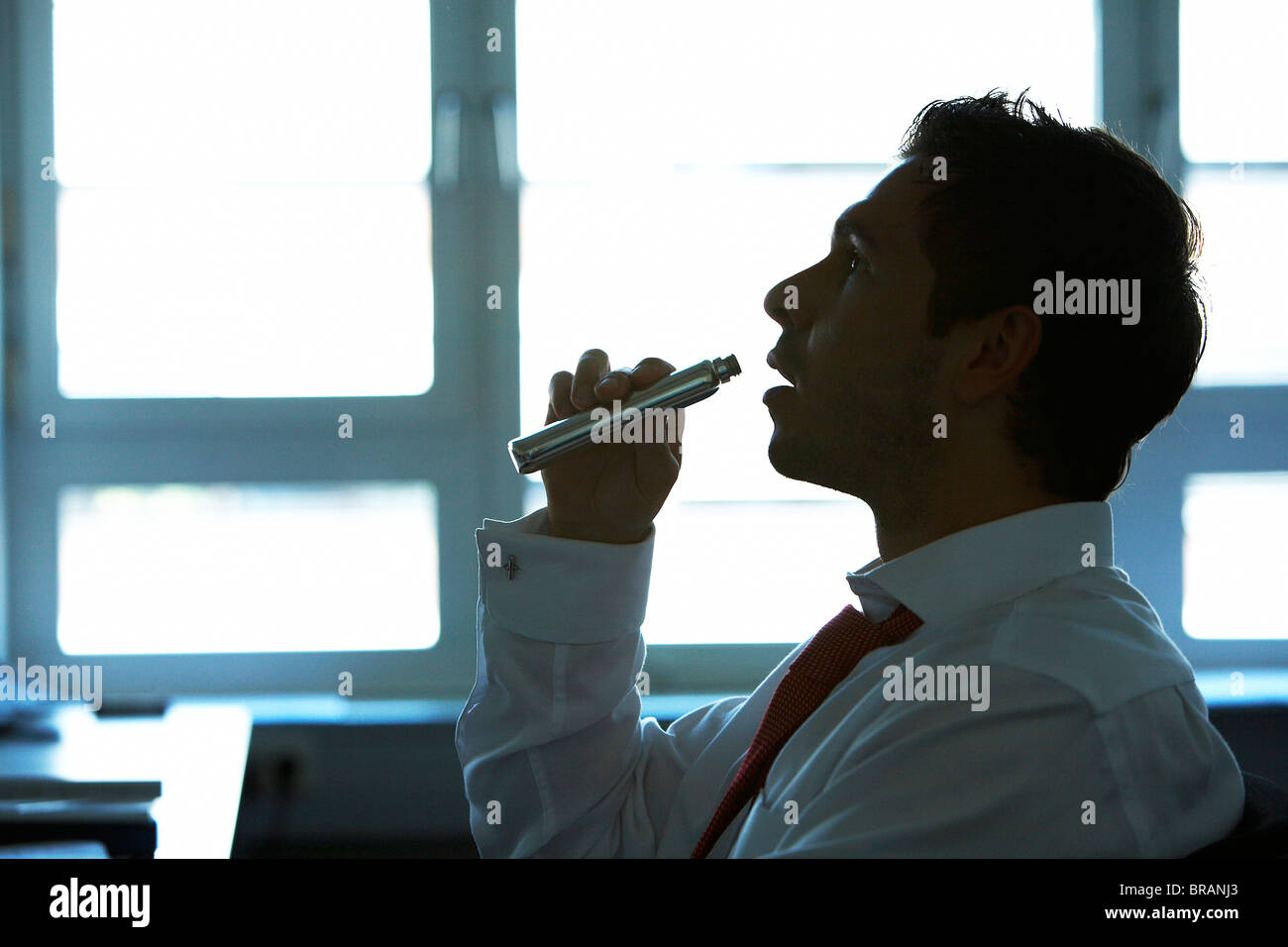 Man drinking alcohol at work Stock Photo Alamy