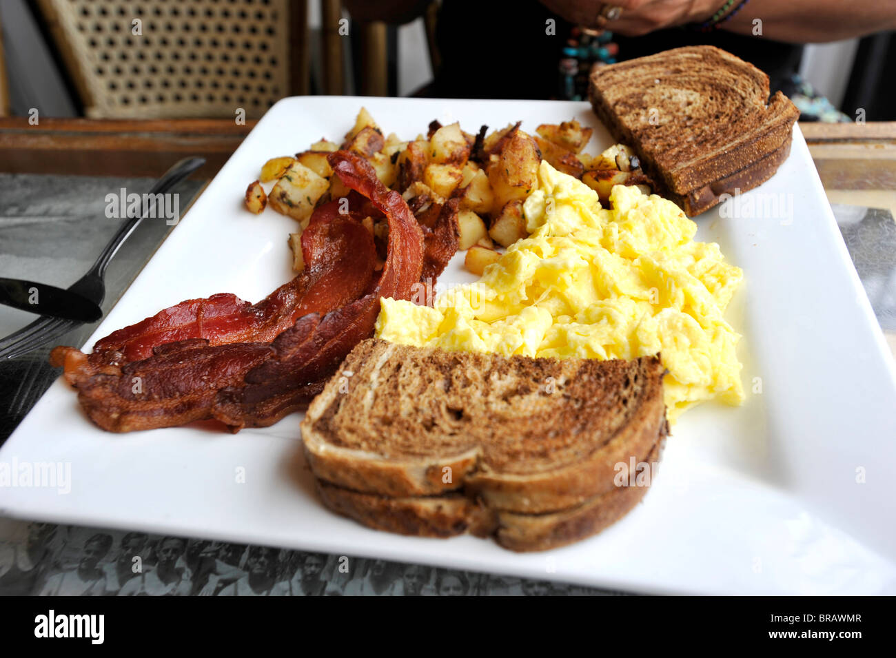 Well cooked bacon with scrambled egg breakfast Stock Photo