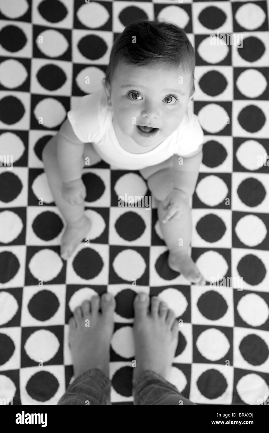 Smiling baby on geometric patterned blanket Stock Photo