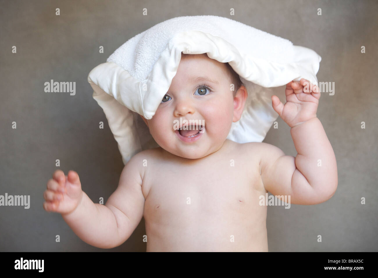 Baby smiling with a blanket on his head Stock Photo Alamy