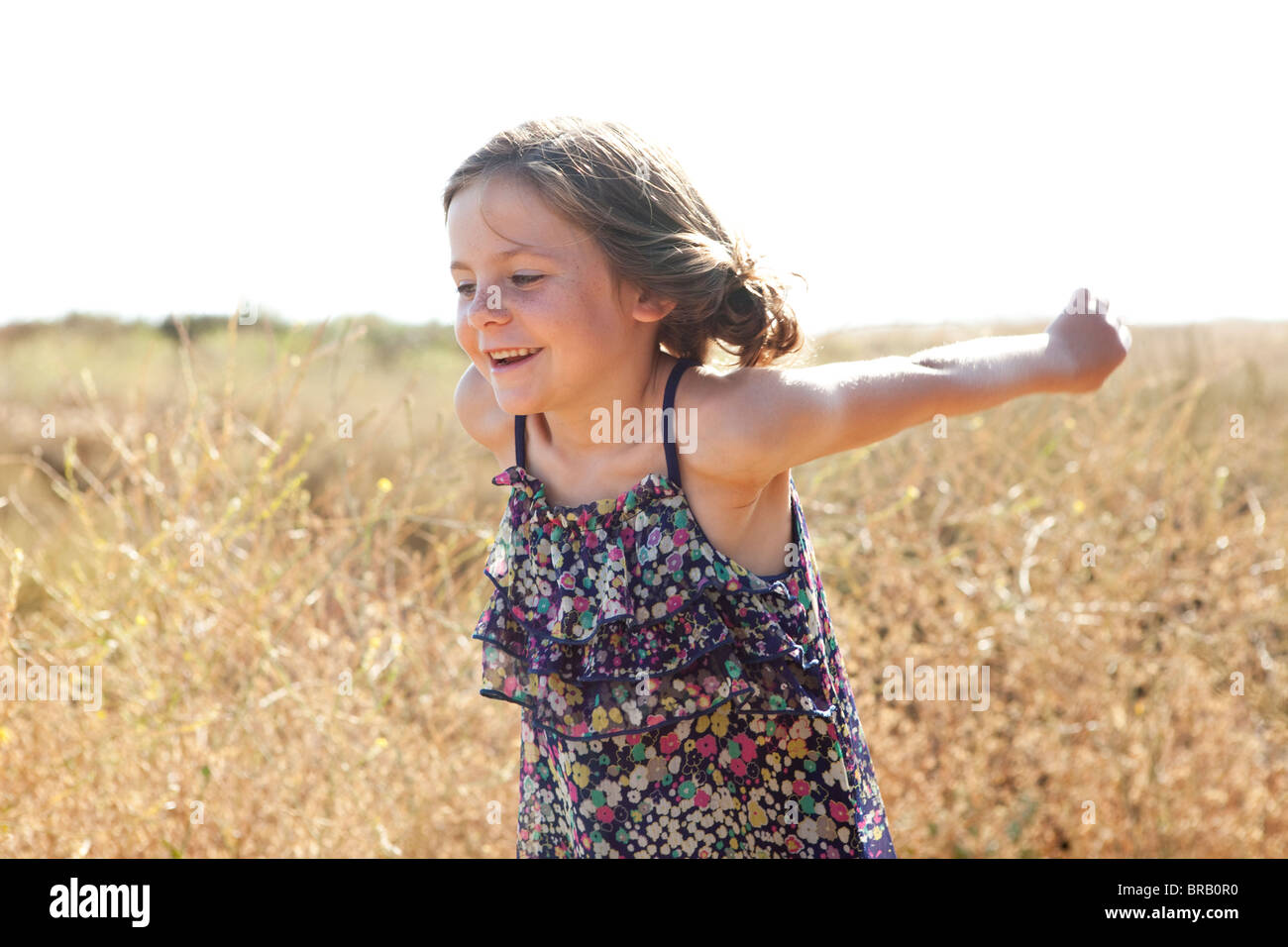 Little girl playing in a field Stock Photo