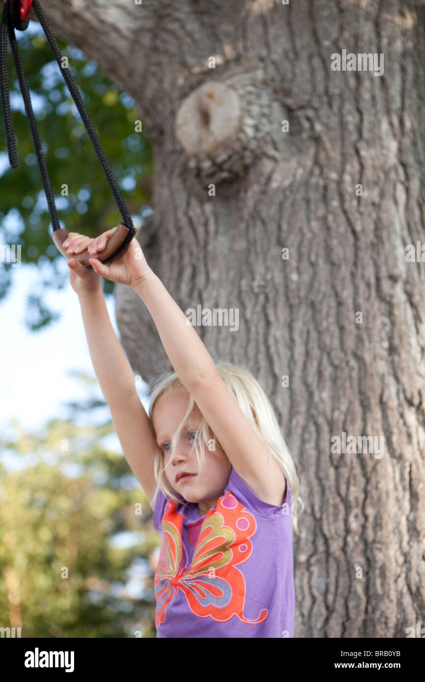 Young girl hanging from zip line Stock Photo