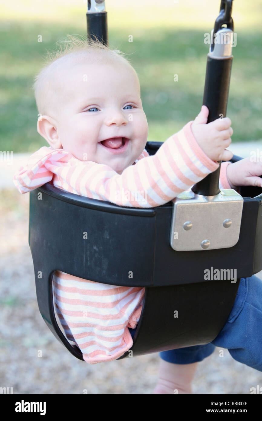 A Baby Sitting In A Swing Stock Photo Alamy