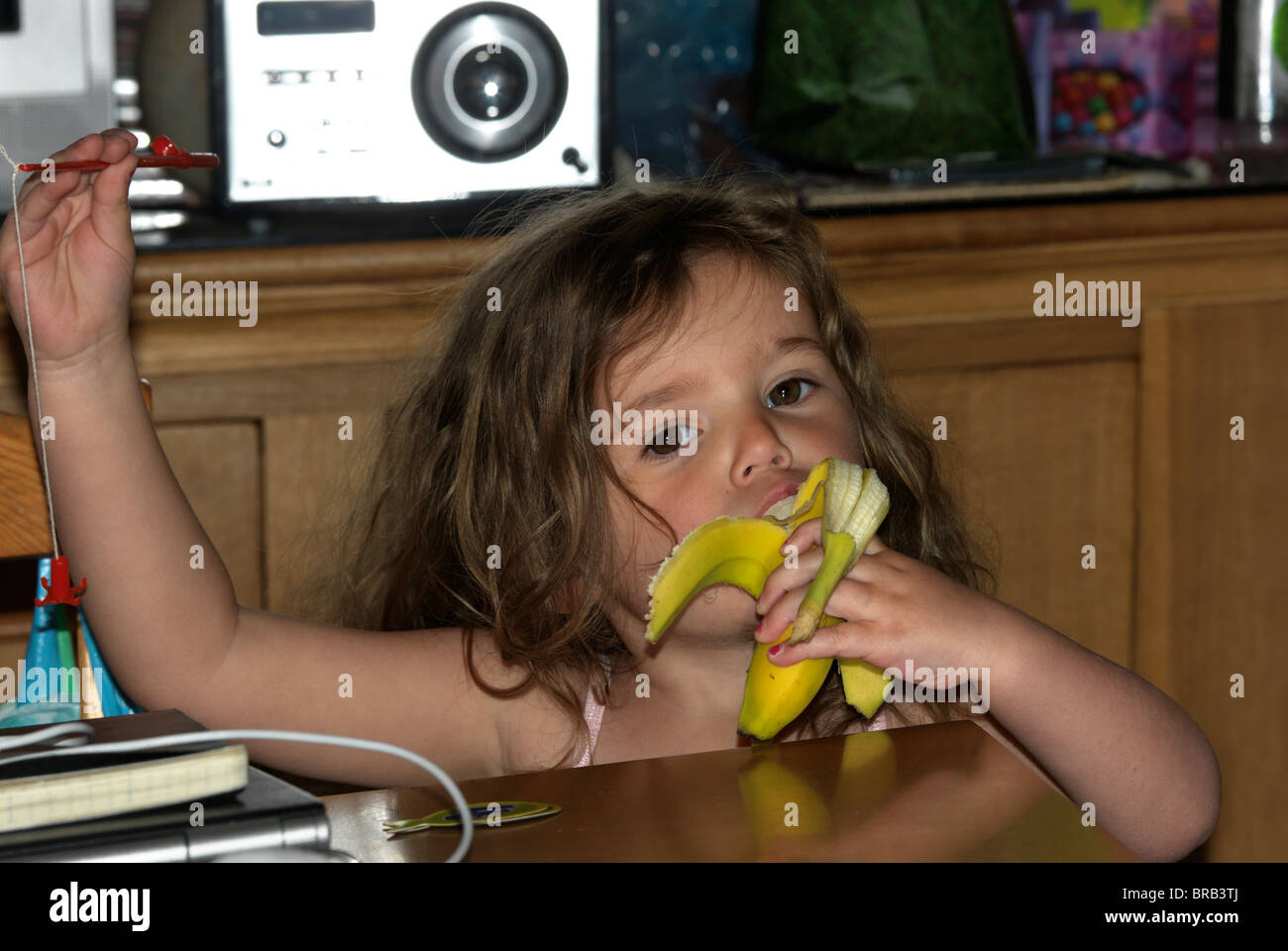 Young Girl Eating A Banana Stock Photo - Alamy