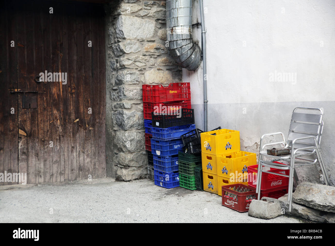 Old coca-cola crates outside a dusty wooden restaurant kitchen back door on a run-down backstreet Stock Photo