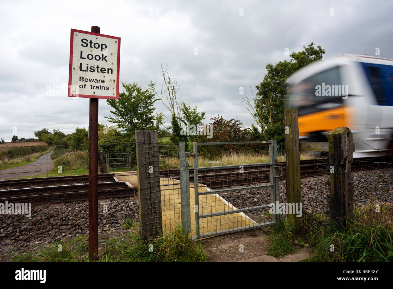 Rural Pedestrian Level Crossing, Claydon, Banbury, Oxfordshire, UK - Chiltern Railways passenger train passing. Stock Photo