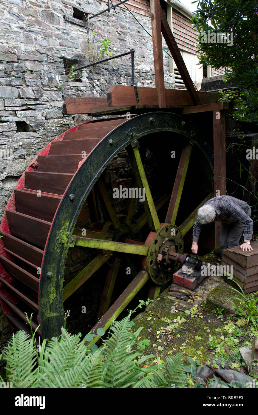 Andrew Parry applying grease to the axle of the waterwheel at Felin Ganol Watermill. Llanrhystud, Ceredigion., Wales UK Stock Photo