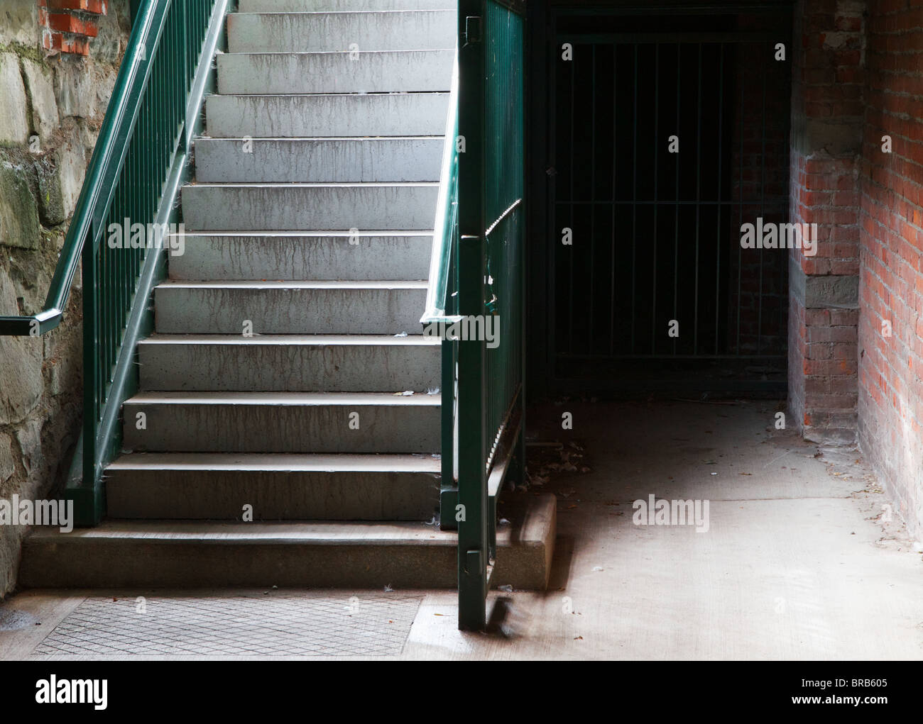 Green railing City Cellar Stairs leading down to stone and brick lower level Stock Photo
