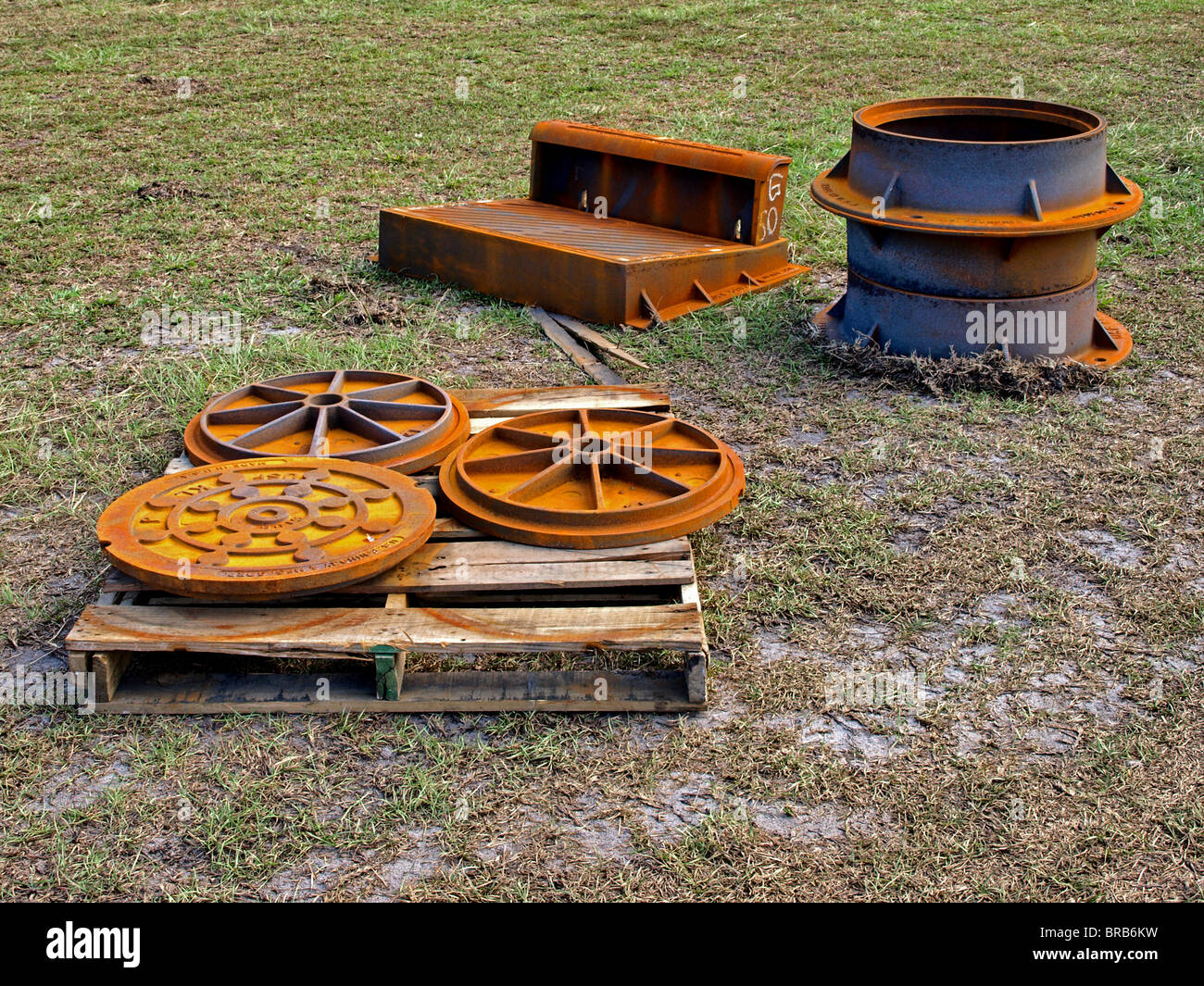 parts for street storm drainage system drain manholes steel connectors rusted street road Stock Photo