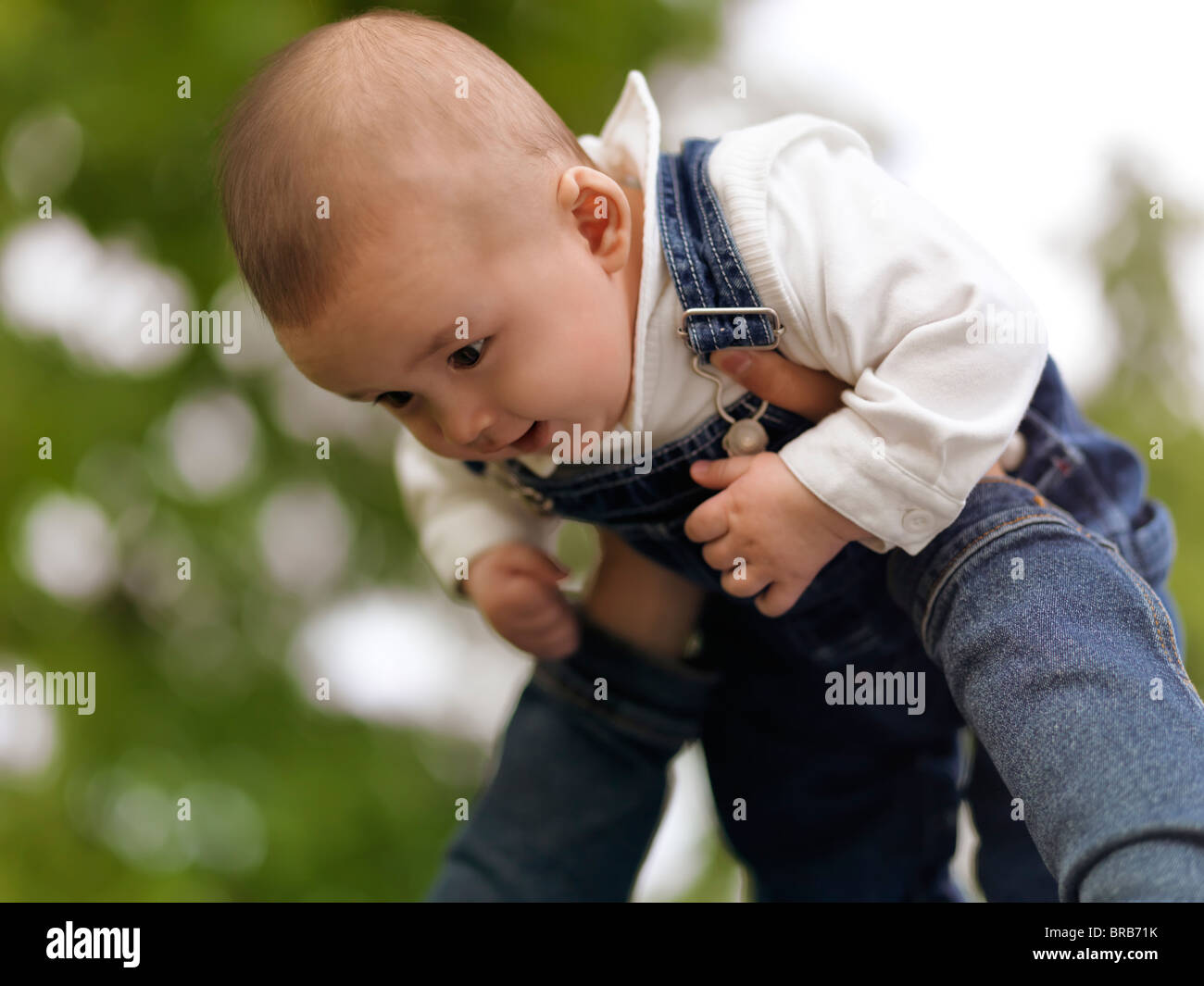 Mother playing with a happy smiling four month old baby boy in the nature Stock Photo