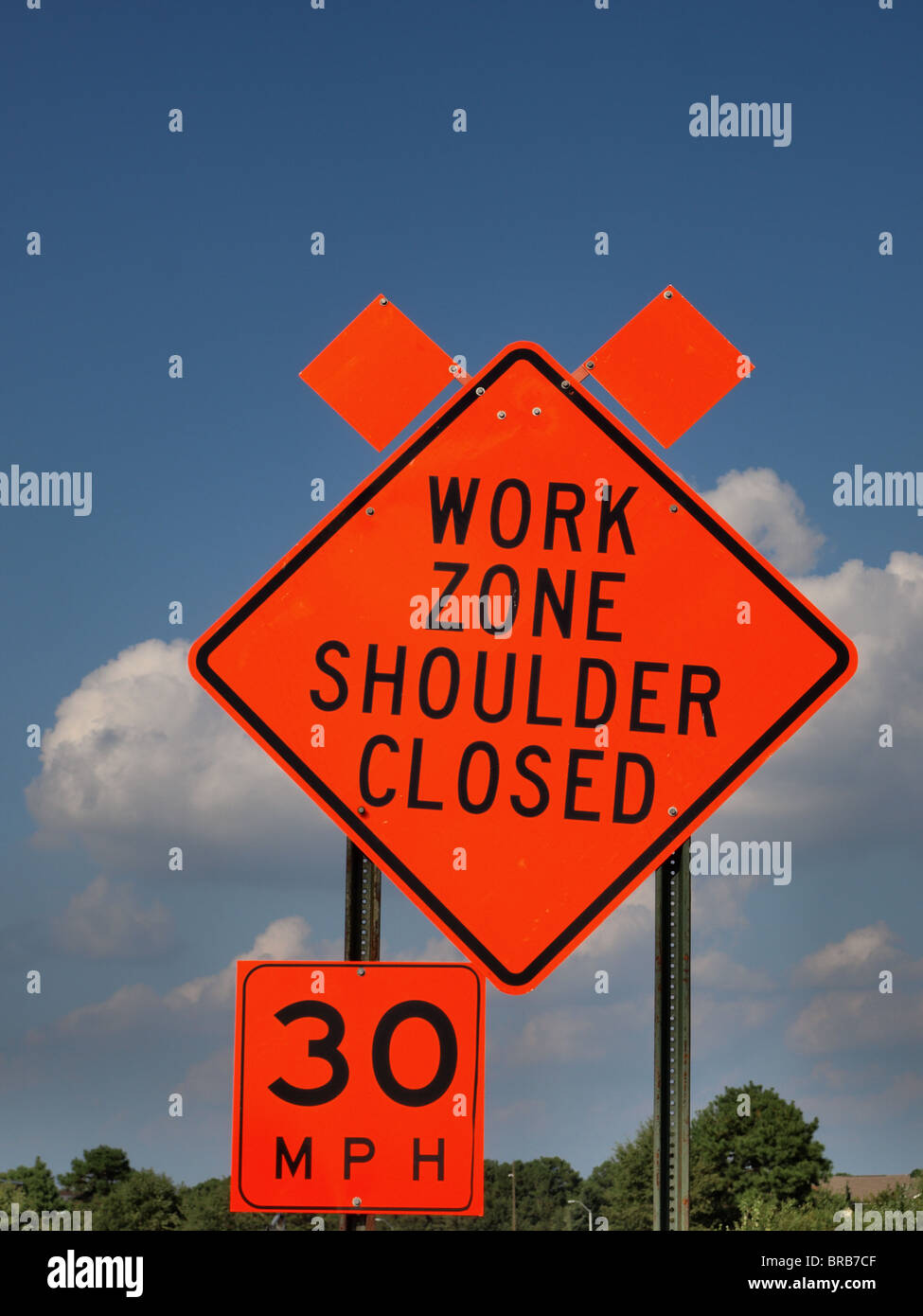 road construction sign orange work zone shoulder closed speed limit clouds warning Stock Photo