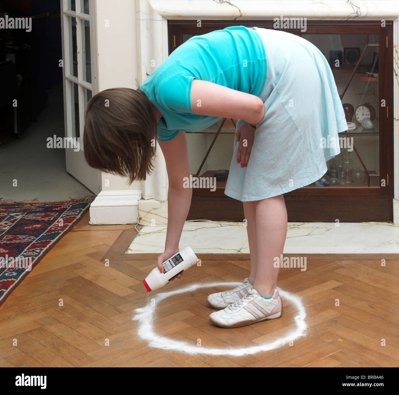 A Caucasian woman sprinkling a salt circle around herself Stock Photo