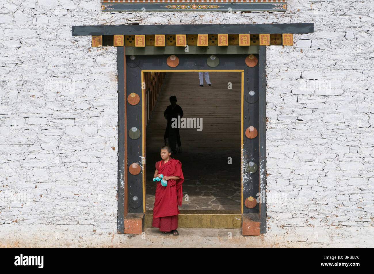 Buddhist monk leaving building, Chimi Lhakhang, Bhutan Stock Photo