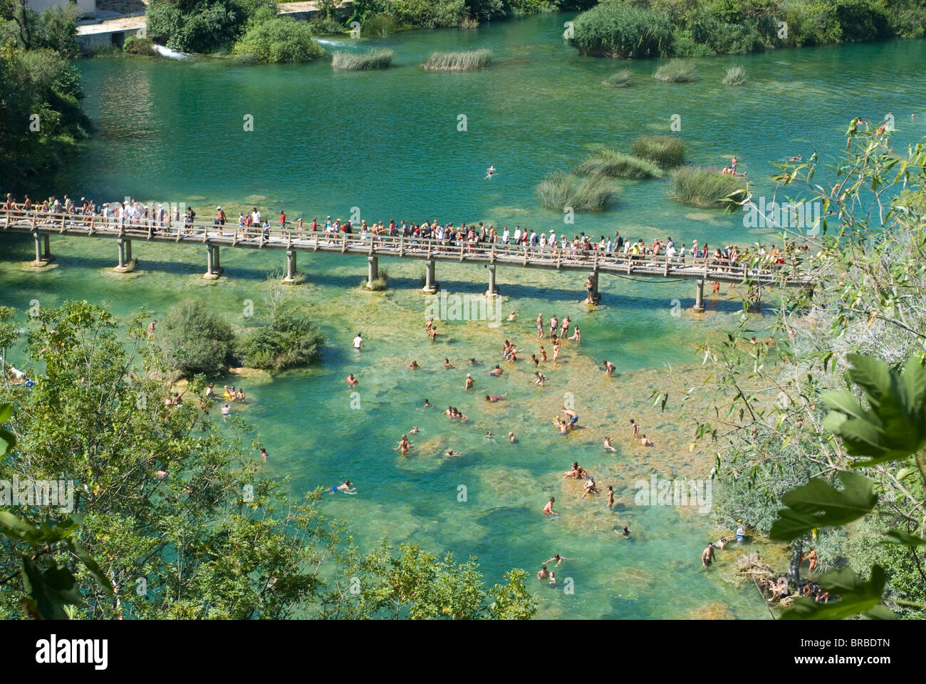 Bridge with many tourists above turquoise water in the Krka National Park, Croatia Stock Photo