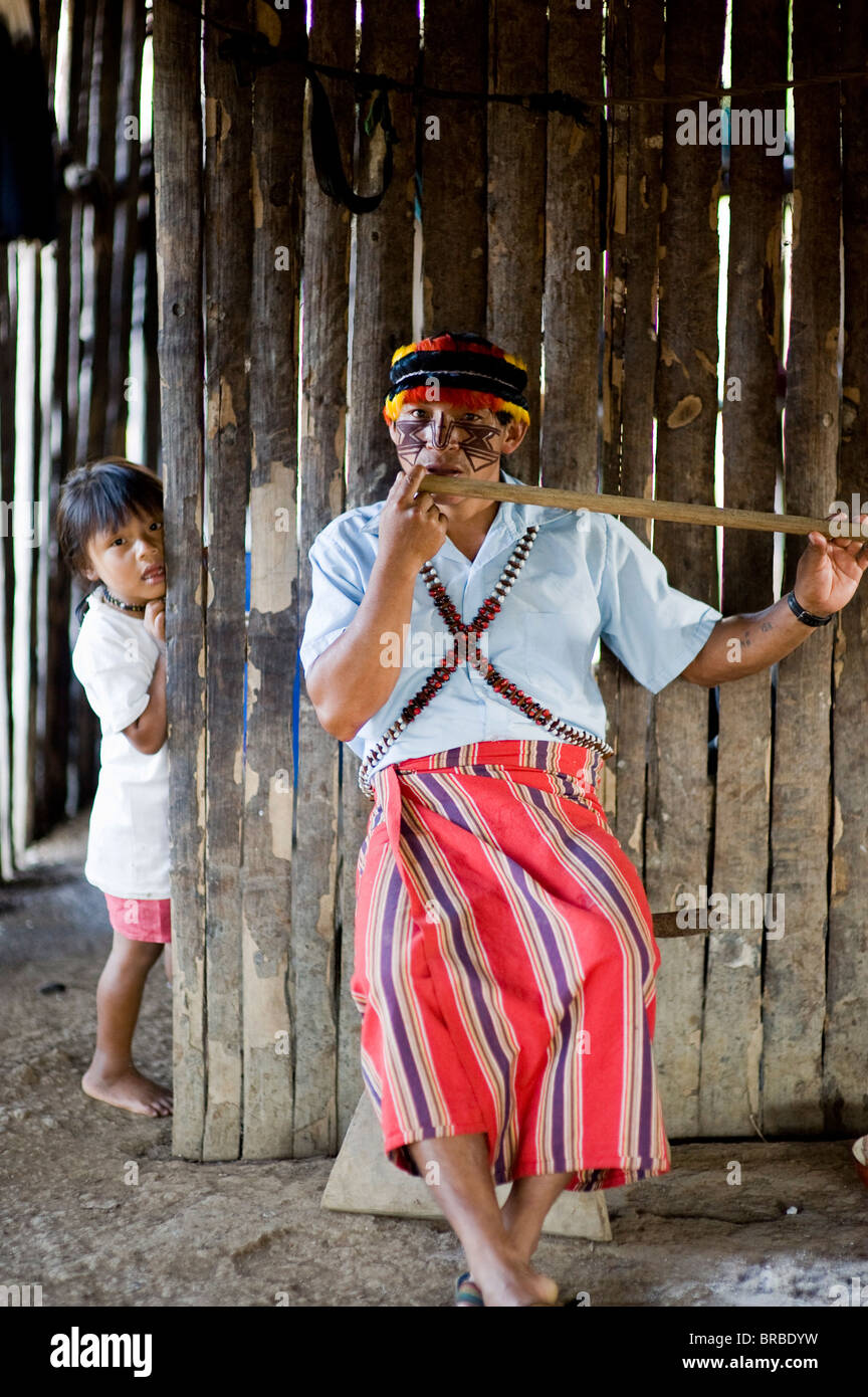 An Achuar man plays an Achuar flute, Amazon, Ecuador Stock Photo