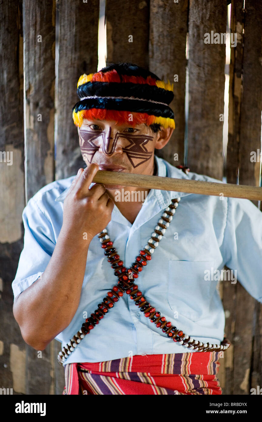 An Achuar man plays an Achuar flute, Amazon, Ecuador Stock Photo