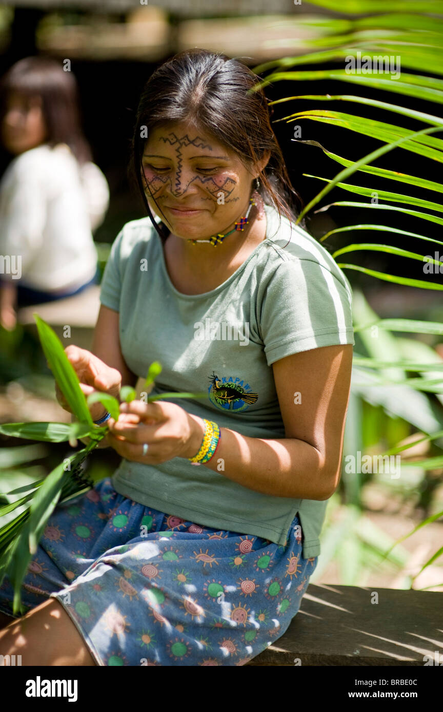 An Achuar woman makes roofing from leaves, Amazon, Ecuador Stock Photo