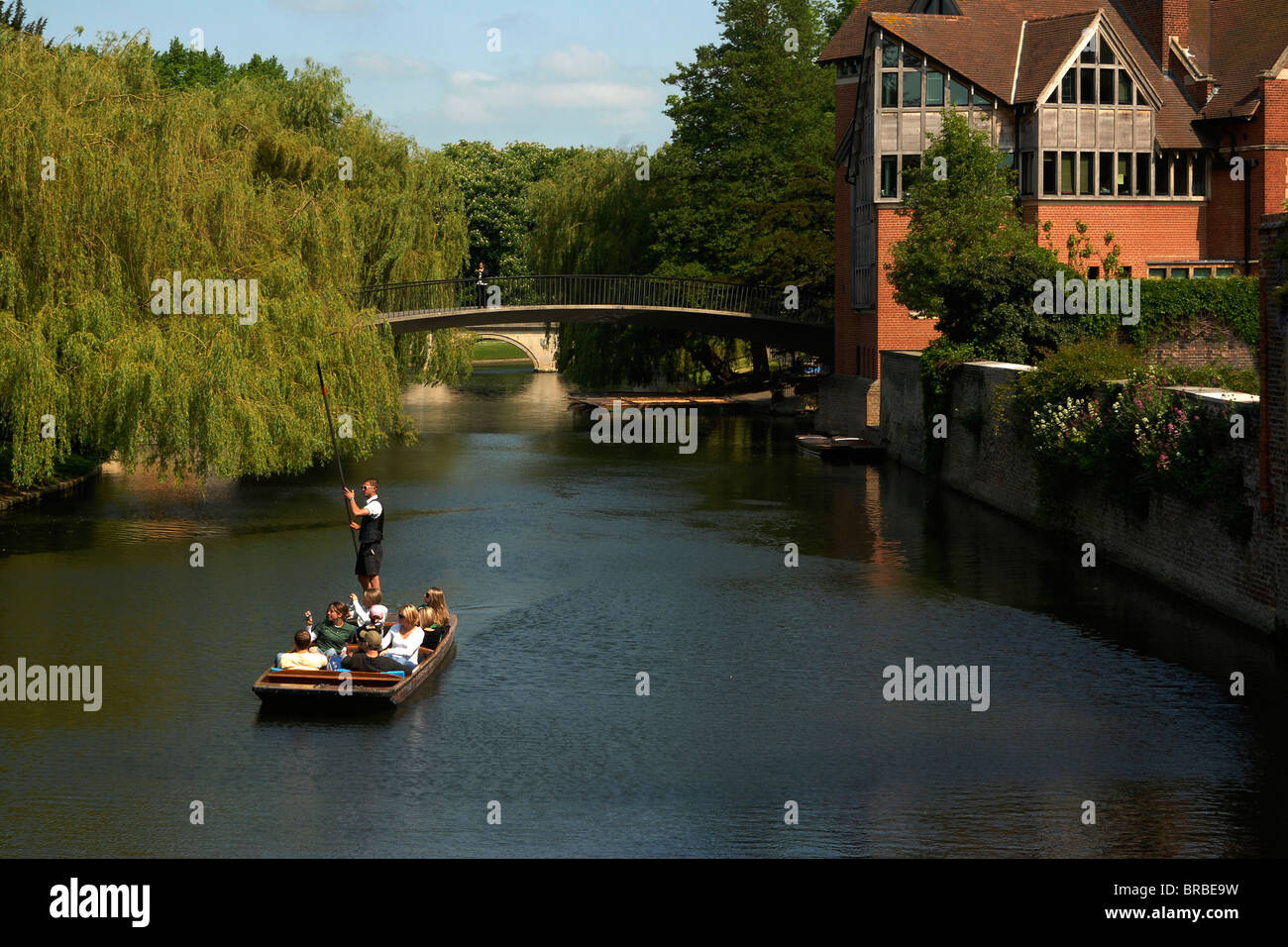 A party of tourists enjoying a chauffeured punt ride on the River Cam through central Cambridge Stock Photo